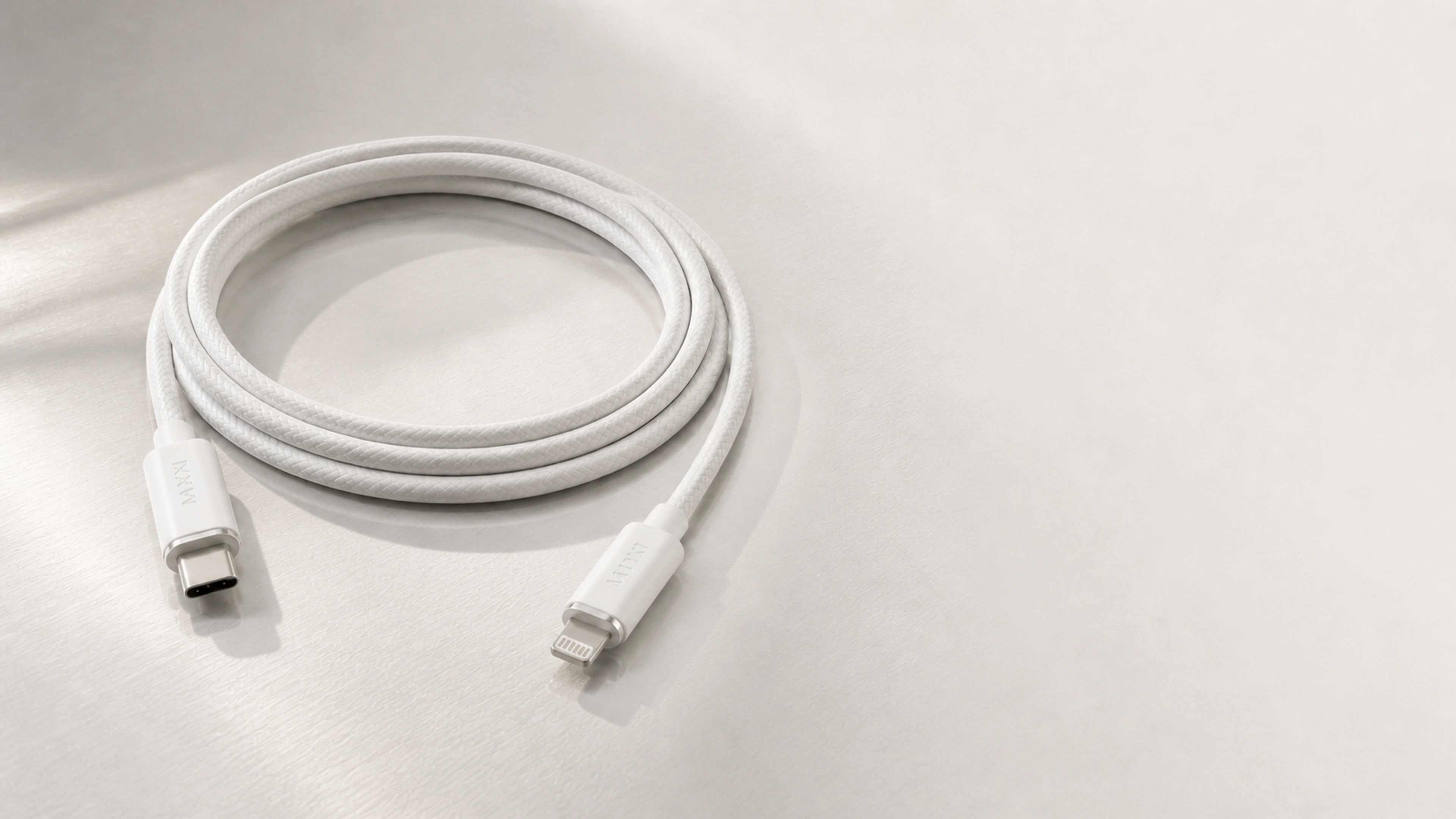 一条完整 1.2 米霜月白 C3 圆编织线自然连续盘绕约三圈,USB-C 与 Lightning 两端完整可见